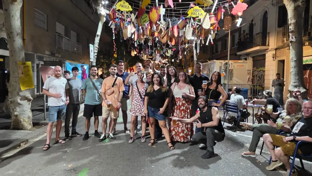 Multicultural group celebrating Barcelona’s Fiestas de Sants 2025 with concerts, dancing, and Catalan traditions.