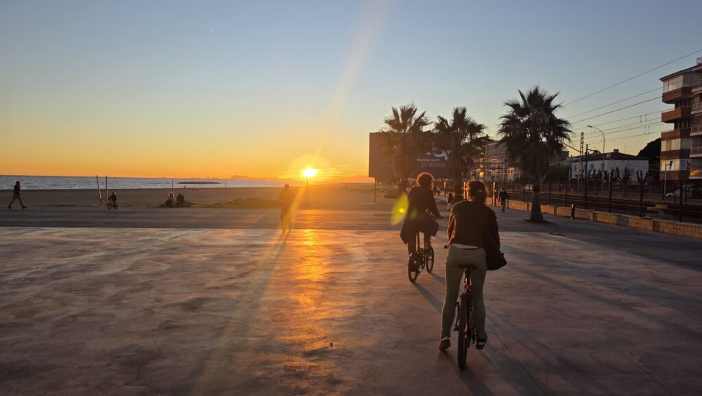 Smiling group cycling together from Girona Metro to the Mediterranean coast, arriving in Premià de Mar during a social bike adventure in Barcelona.