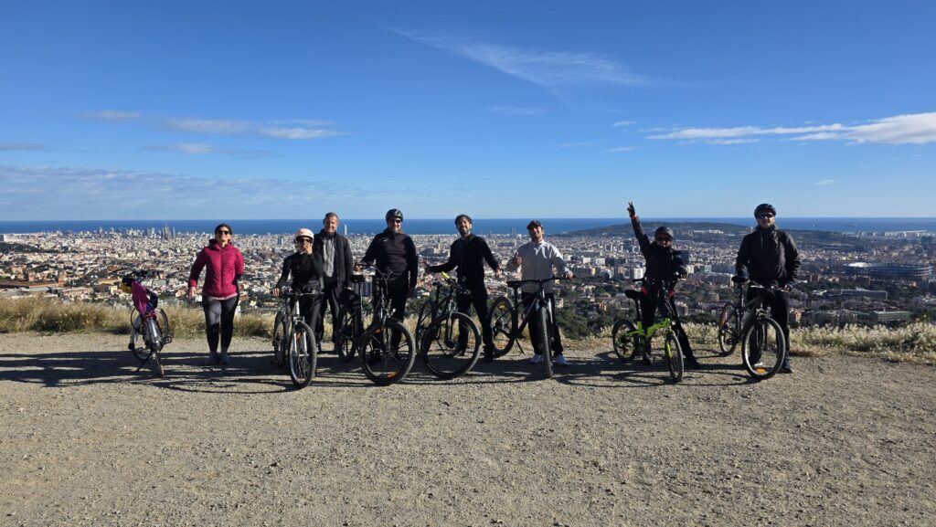 Group cycling on Carretera de las Aguas in Barcelona with panoramic city and sea views from Collserola.