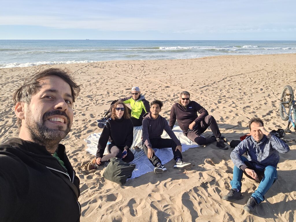 Group cycling to El Prat Beach in Barcelona with airplane landing overhead near Barcelona Airport.