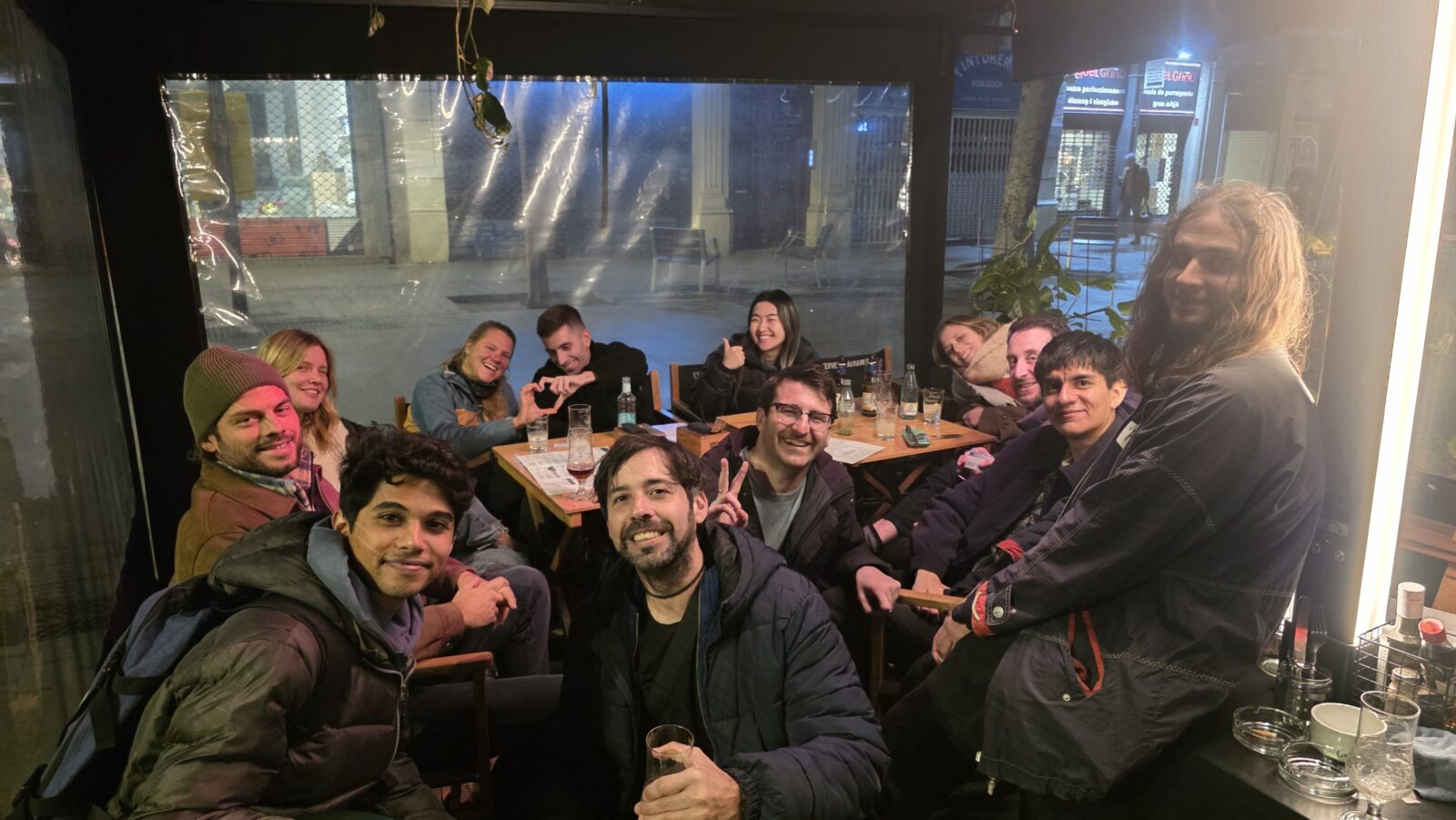 International group enjoying a social meetup in a bar in Barcelona during the Sant Antoni festival night